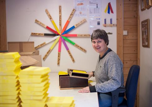 Kvinne sitter ved pult og arbeider